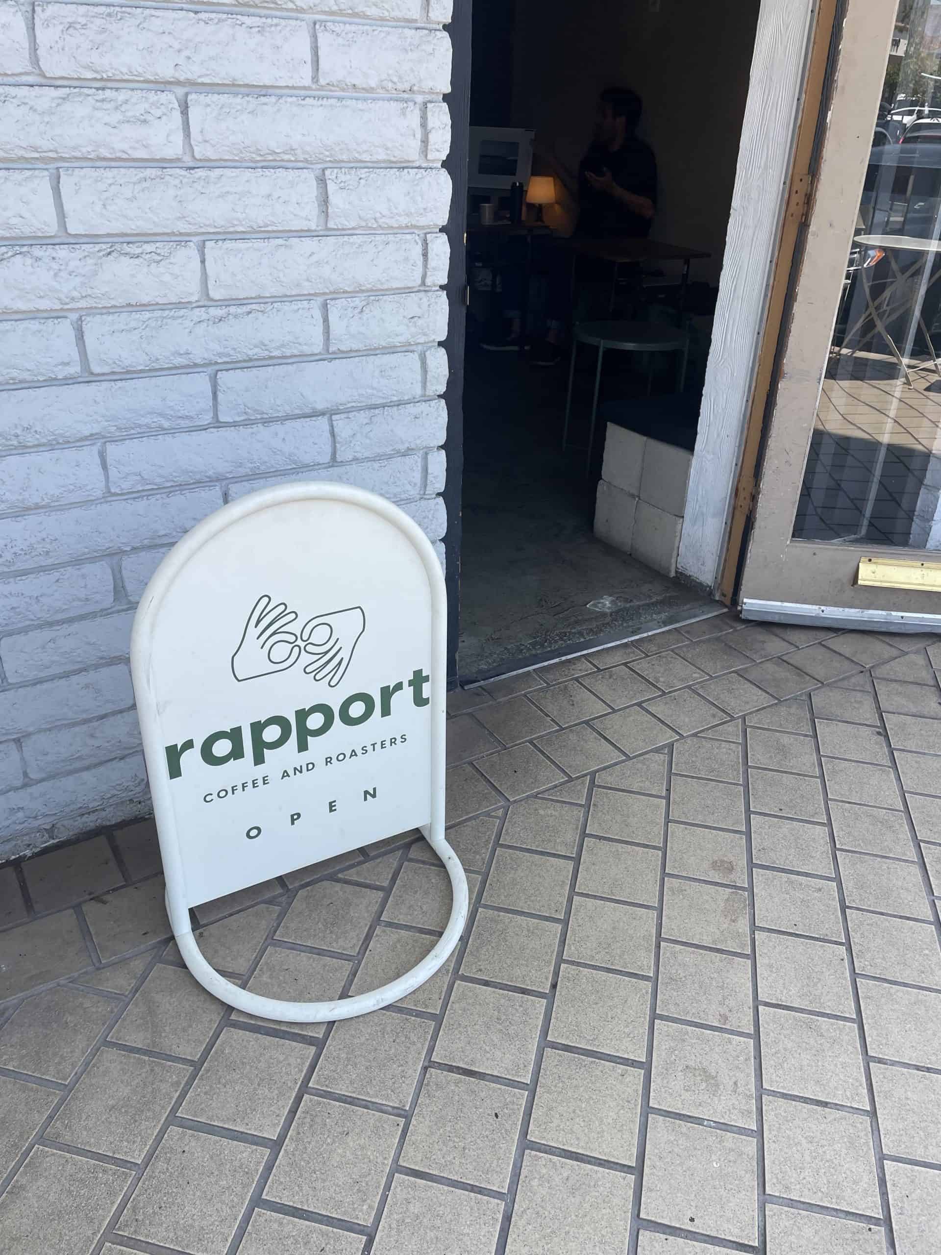 Rapport Coffee Roasters green and white sign that says 'rapport coffee and roastert' in front of their coffee shop in San Clemente