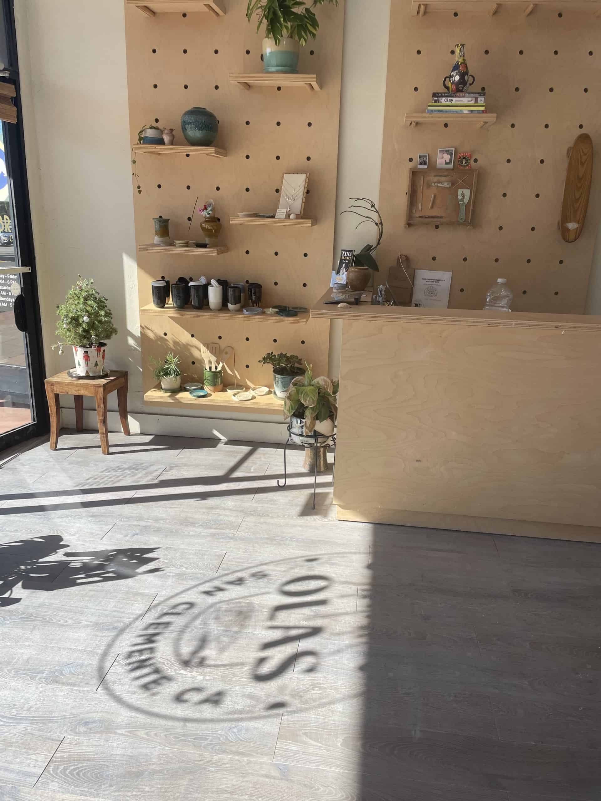 Pottery Studio wall with wooden shelves and the light shining from the sun in a window