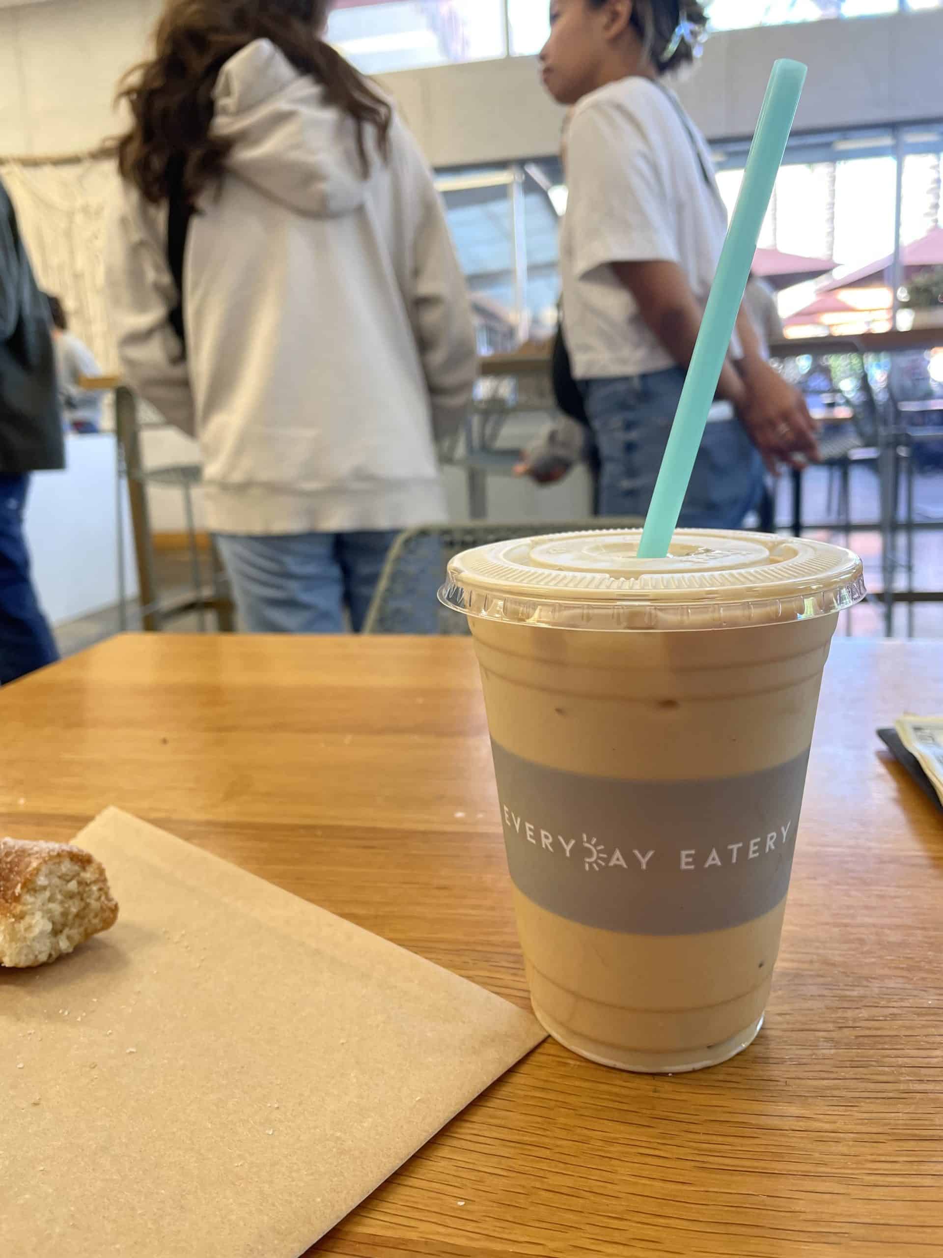 Iced latte in a plastic cup with a grey and white Everyday Eatery sticker